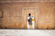 Woman Standing And Hand Stretching At The Door Of An Old Fort
