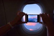 Woman Immortalising The Sunrise Through Airplane Window
