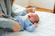© VeaVea/Stocksy - Newborn baby lying on the bed, crying.