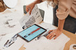 © Wells/Stocksy - Young female fashion designer uses her tablet to make fashion sketches