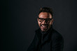 © MyMicrostock/Stocksy - Portrait of happy handsome man over dark background looking at c