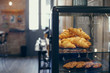 © Miquel Llonch/Stocksy - Close up of a display case with croissants and cookies in a coffee shop