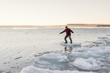 Man Playfully Balances And Rides Floating Chunk Of Ice