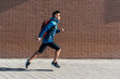© Santi Nunez/Stocksy - Handsome asian man running in the city.