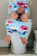 © Raymond Forbes LLC/Stocksy - Child Seated on Toilet