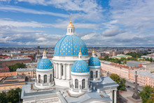 The Famous Trinity Cathedral With Blue Domes And Gilded Stars, View Of The Historic Part Of The City Of Staint-Petersburg, Typical Houses Around.