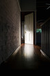 © Angela Lumsden/Stocksy - Light from a room illuminates a door in a dark hallway