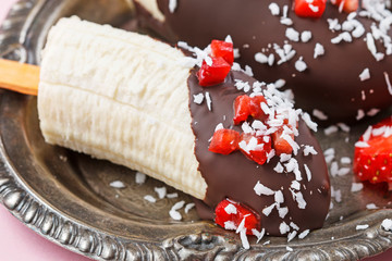 Canvas Print - Chocolate dipped bananas with strawberries and coconut flakes.