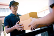 © wutzkoh - Close up of hands cargo staff are delivering cardboard boxes with parcels inside to the recipient's hand.