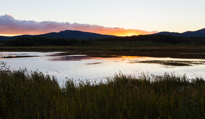 Wall Mural - Summer landscape with river flowing betweeen the green hills on background of colorful sunset sky. Ural region,Russia.