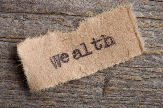 wealth text printed with typescript, on wooden background