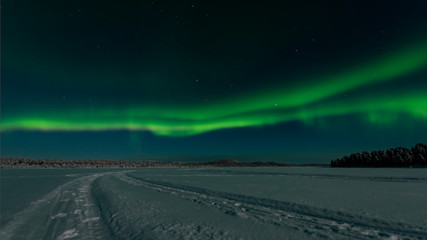 ooking across a frozen lake to the northern lights