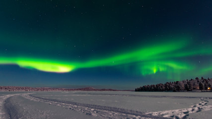 finland, helsinki - jan 2019: view across the lake toward a forest as the northern light rise in to 