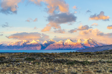 Beautiful dawn golden orange light of sun rise over the snow mountain with deep blue lake in the morning with cloud in beside the road from El Calafate to El Chalten, south Patagonia, Argentina