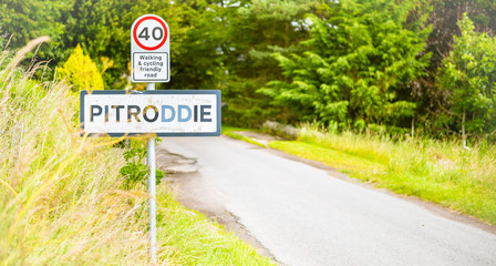 Pitroddie village sign on countryside road in central Scotland. 40 miles speed limit sign