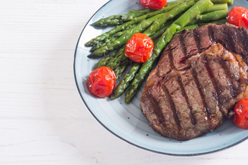 Wall Mural - Grilled beef steak ribeye with cherry tomatoes and asparagus