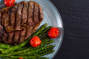 Wall Mural - Grilled beef steak ribeye with cherry tomatoes and asparagus