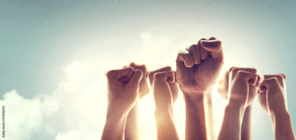 Peoples raised fist air fighting and sunlight effect, Competition, teamwork concept. - obrazy, fototapety, plakaty 