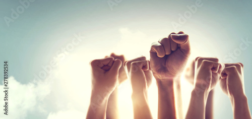 Fotomural Peoples raised fist air fighting and sunlight effect, Competition, teamwork concept
