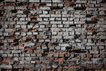 Old brick wall texture. The wall, made of old red bricks, darkened by old age. Ancient vintage brick wall background. Brick wall backdrop