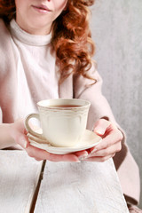  A woman is giving a cup of tea.
