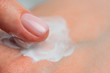 © Artem Markin - Fingers apply cream to skin. Close up