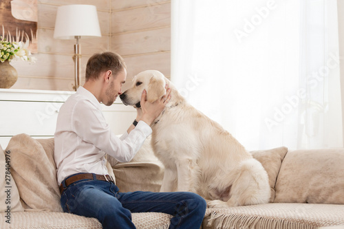 Young Handsome Guy Teaches His Big Dog To The Rules Sitting On The