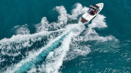 Aerial bird's eye view photo taken by drone of boat cruising in Caribbean tropical beach with turquoise - sapphire waters