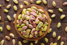 Pistachios Nuts Peeled In Wooden Bowl, Top View.