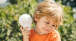 © Tverdokhlib - Handsome boy with a light bulb. An elaborate explorer. The lessons of physics. Little scientist. A smart boy teaches how a light bulb works. Cute child with idea icon.
