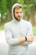 seriousness and masculinity. sportswear fashion. sportsman relax after training outdoor. handsome unshaven man in hood. man in hood. casual style. male fashion. unshaven guy outdoor. be sporty