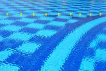 Blue Water Surface Of Swimming Pool With Yellow Buoys Line
