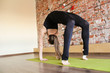© Alexandr - Hatha yoga girl on the background of a beautiful red brick wall in the pose of Ardha Chakrasana