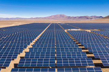 Aerial view of hundreds solar energy modules or panels rows along the dry lands at Atacama Desert, Chile. Huge Photovoltaic PV Plant in the middle of the desert from an aerial drone point of view