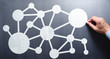 © tadamichi - Network communication concept. Businessman drawing network structure on chalkboard.