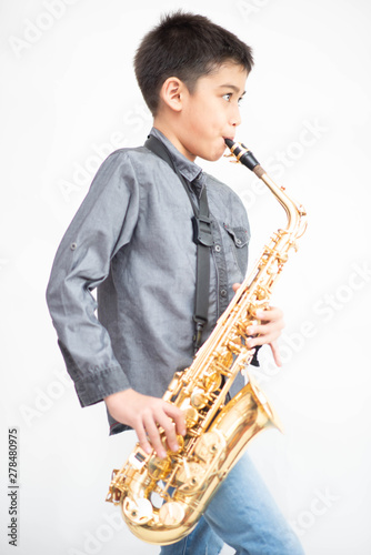 Fotografía Little asian musician boy playing saxophone instrument