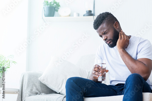 African american man suffering from neck pain at home Fototapet