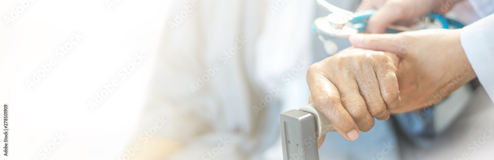 Elderly female hand holding hand of young caregiver at nursing home.Geriatric doctor or geriatrician concept. Doctor physician hand on happy elderly senior patient to comfort in hospital examination - obrazy, fototapety, plakaty 
