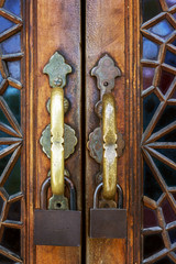 Decorative antique wooden door with two metal locks close up on building in Sheki, Azerbaijan