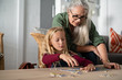 © Rido - Girl doing jigsaw puzzle with grandmother