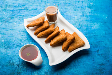 Poster - crispy Potato triangles or batata vada covered with bread crumbs and then deep fried. served with tomato ketchup. selective focus