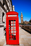 Fototapeta Big Ben - Iconic Red Telephone Booth and Big Ben Clock Tower over blue sky.