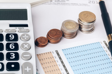 pile of money coins with graph paper on wood table, concept in account, finance and growth of business