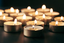 Burning Candle On Table In Darkness, Space For Text. Funeral Symbol