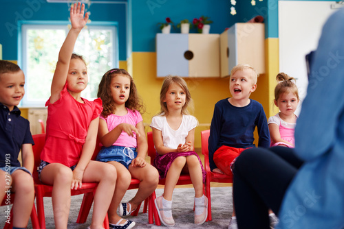 Girl raising her hand to ask question in classroom Canvas Print
