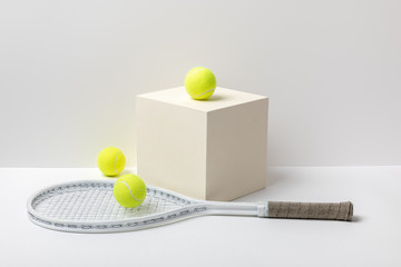 Wall Mural - tennis racket and bright yellow tennis balls on cube on white background