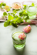Summer Refreshing Beverages . Green Drink In Glass With Ice Cube, Cucumber And Herbs On Light Table Background With Ingredients For Tasty Lemonade Or Infused Water