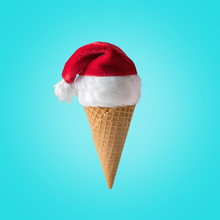 Hat Of Santa Claus With Ice Cream Cone On Blue Background. New Year Or Christmas Minimal Concept.