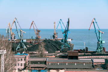 working cranes in a small port in sunny weather. beautiful multi-colored cranes in a small port.