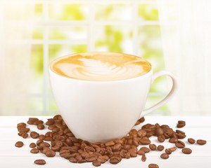 Sticker - Cup of coffee with cream and grains on wooden table